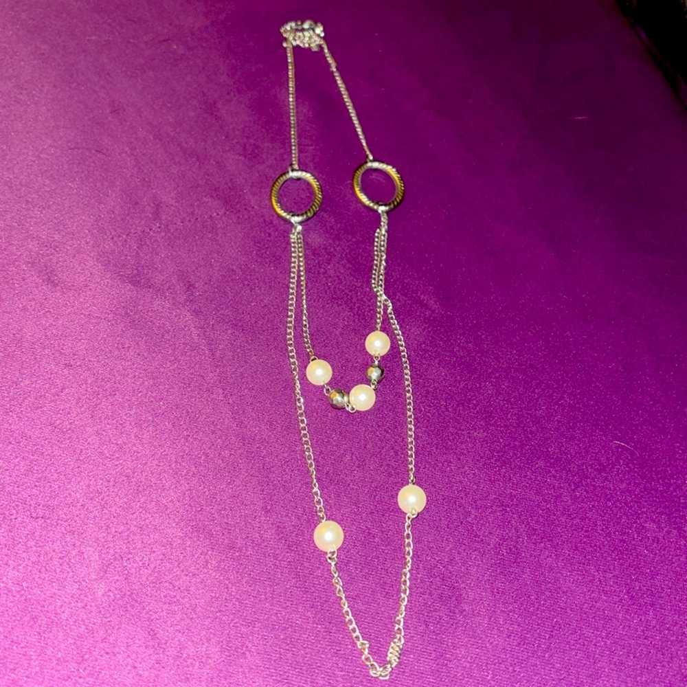Long chain pearl with silver chain and silver details.
